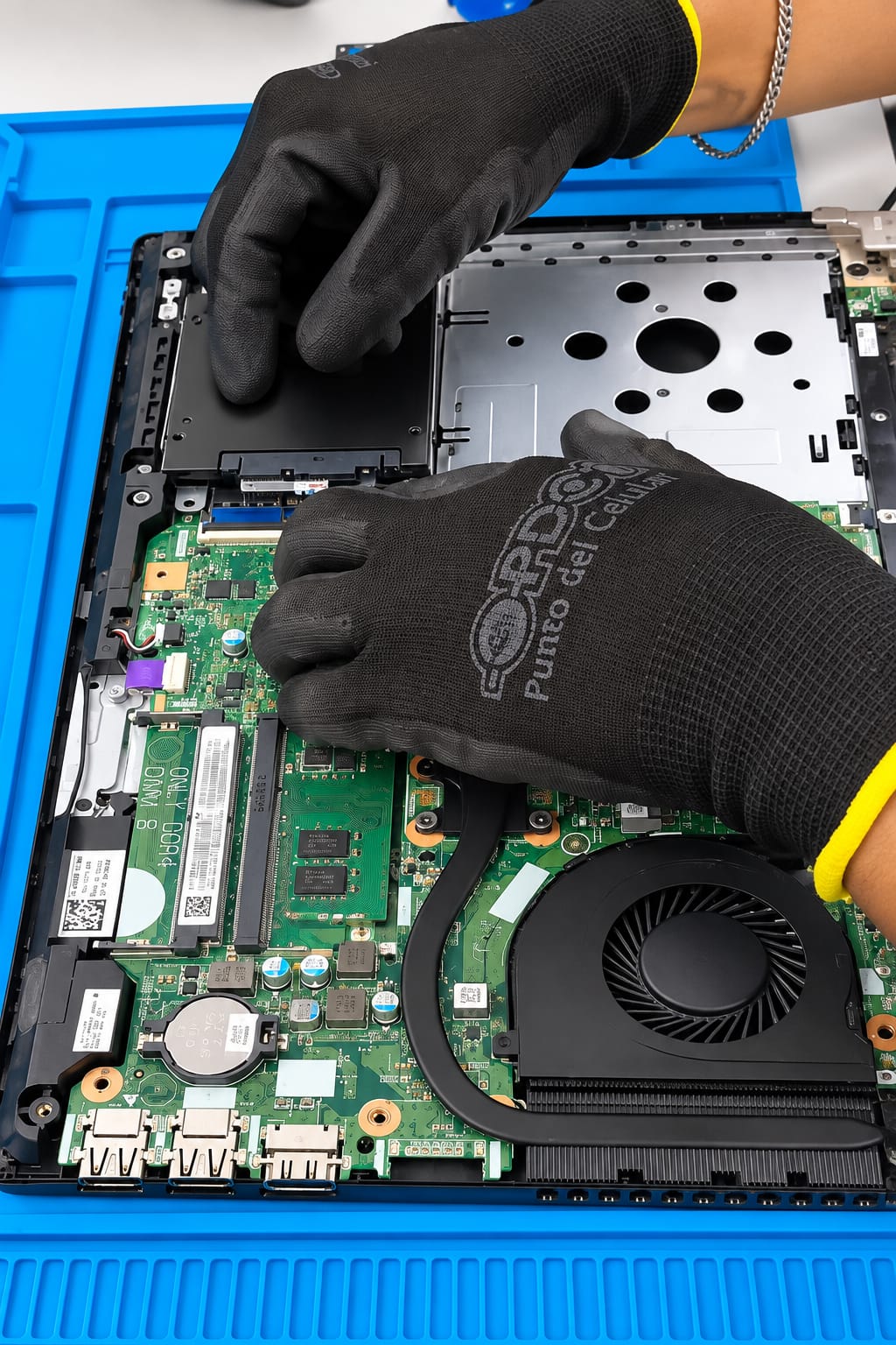 Técnico cambiando la batería y revisando la placa de una laptop